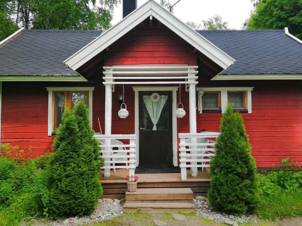 czerwony dom z gankiem i drzwiami w obiekcie Holiday Home Ruokovirran mökki by Interhome w mieście Siilinjärvi
