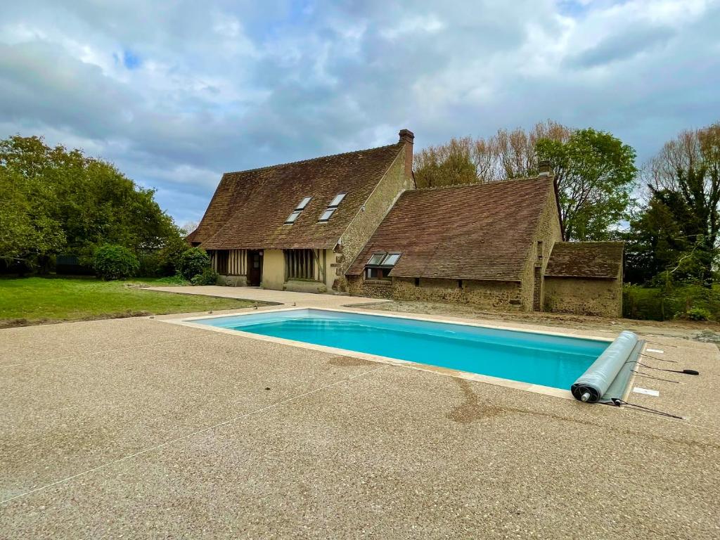 a swimming pool in front of a house at villa festive HOMAZING piscine privée 2h de Paris in Choué