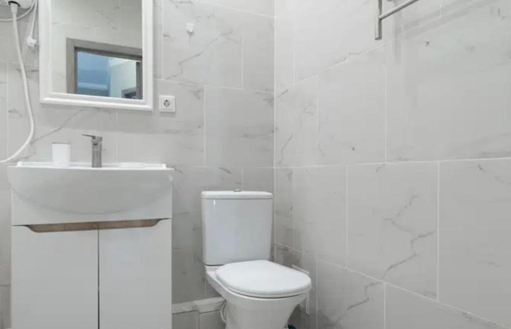 een witte badkamer met een toilet en een wastafel bij VIP apart 607 in Tbilisi City
