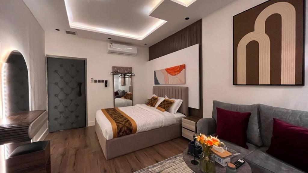 um quarto com uma cama e um sofá em استديو حطين أنيق مقابل البوليفارد مدخل خاص em Riyadh