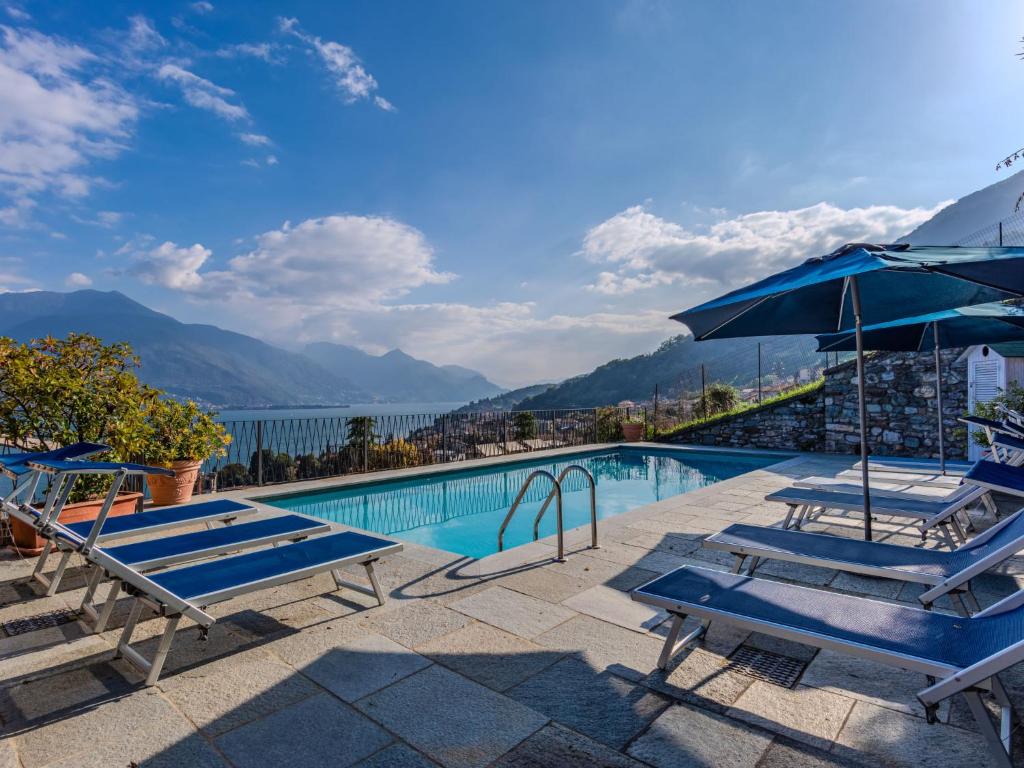 a pool with chairs and umbrellas and a view of the water at Apartment La Pianca-4 by Interhome in Musso