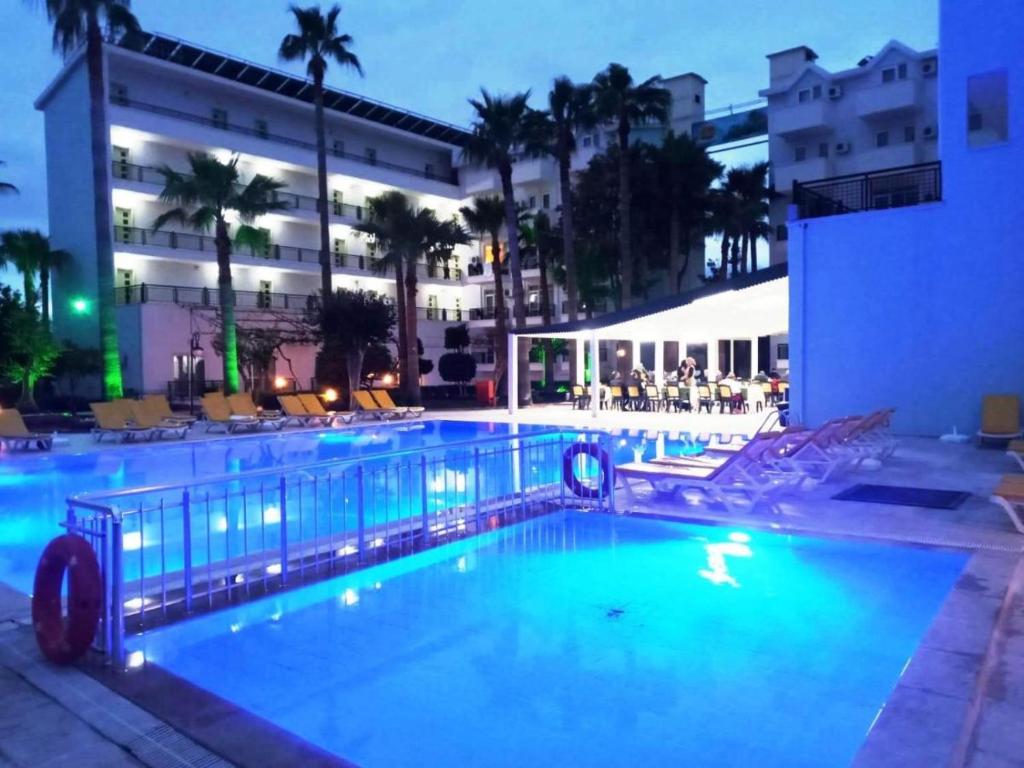 a large swimming pool with a hotel in the background at MALİBU RESORT in Kemer