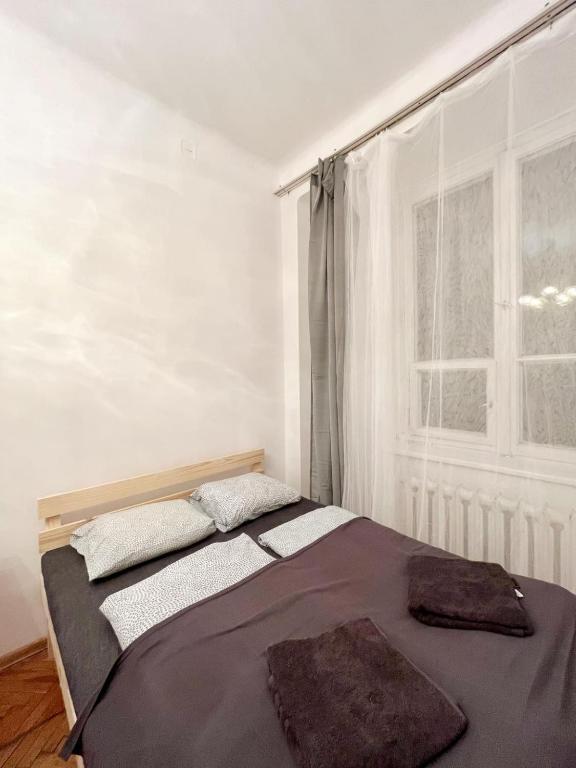 łóżko w pokoju z dużym oknem w obiekcie Cozy studio in Cracow w Krakowie