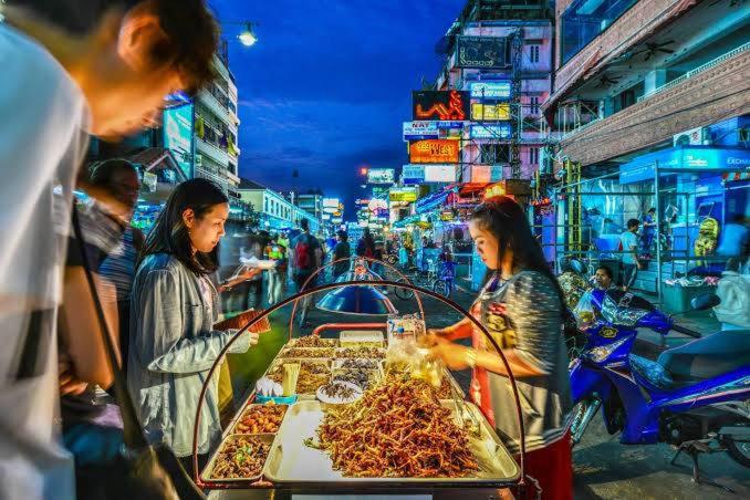 un groupe de personnes achetant des denrées alimentaires sur un marché dans l'établissement wonderful hostel khaosan, à Bangkok