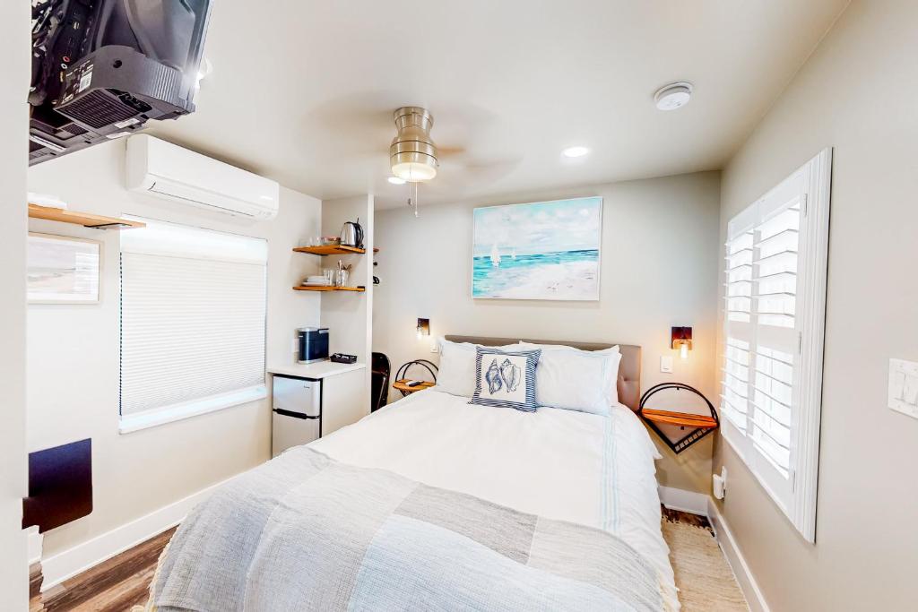 a bedroom with a bed and two windows at Beach 5 Villas #B4 in Fernandina Beach