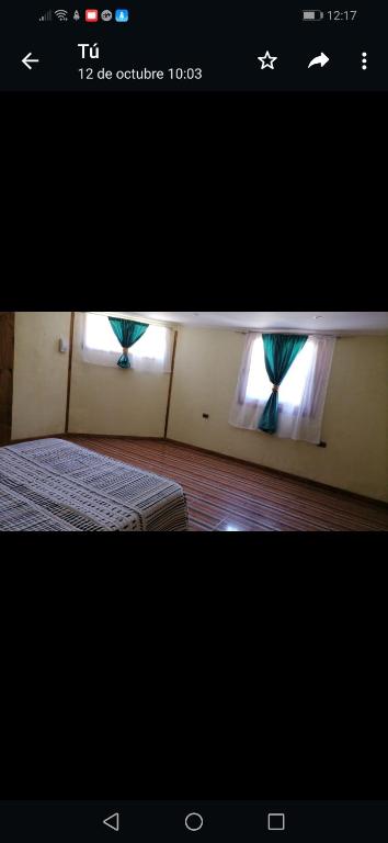 Una foto de un dormitorio con 1 cama y 2 ventanas en Arriendo casa por dias en olmue, en Olmué