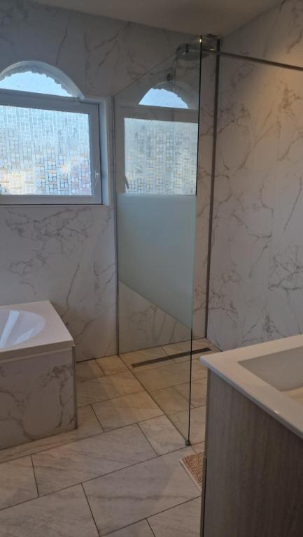 a bathroom with a shower and a sink at Manava Villa vue mer et Mont Saint Michel piscine intérieure in Saint-Jean-le-Thomas