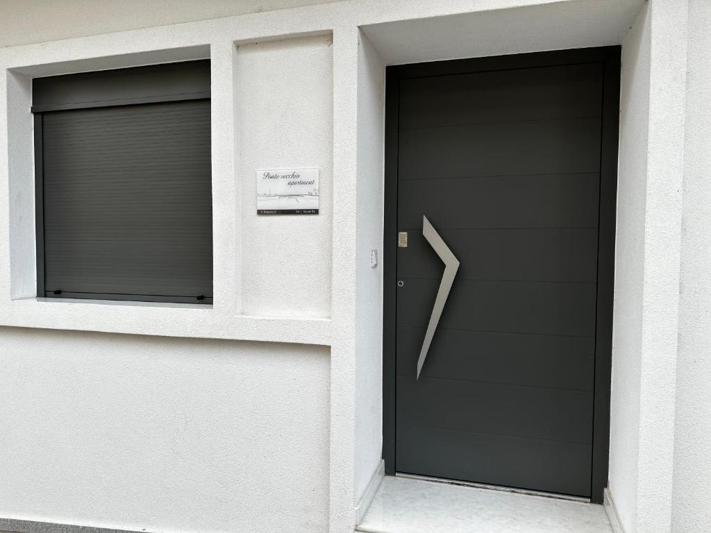 budynek z czarnymi drzwiami i dwoma oknami w obiekcie Ponte vecchio apartment w Chalkidzie