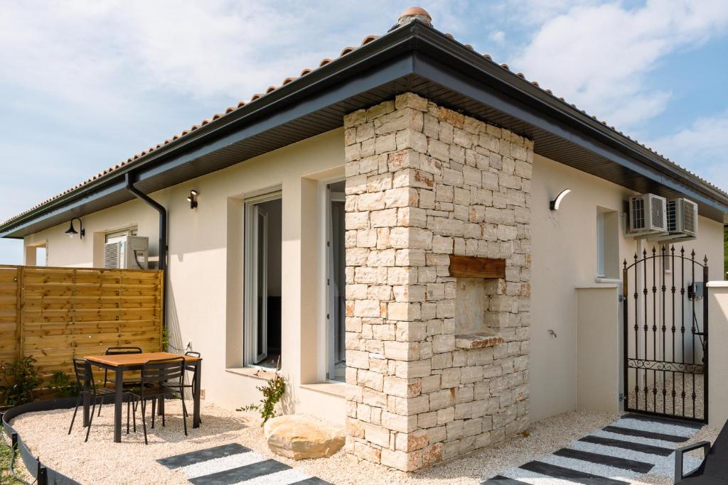 a house with a brick chimney and a table and chairs at ANNA : vue sur les vignes, spa exterieur, sans vis-a-vis in Goudargues