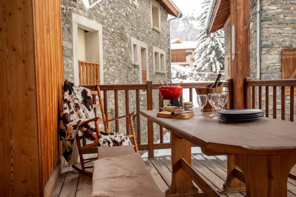 terraza de madera con mesa y sillas en el porche en Chalet Laura en Saint-Marcel