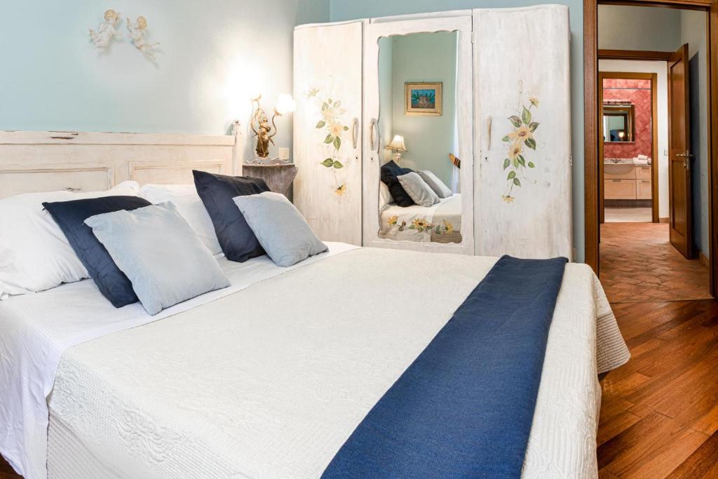 una camera da letto con un grande letto bianco con cuscini blu di Il Casato a Siena