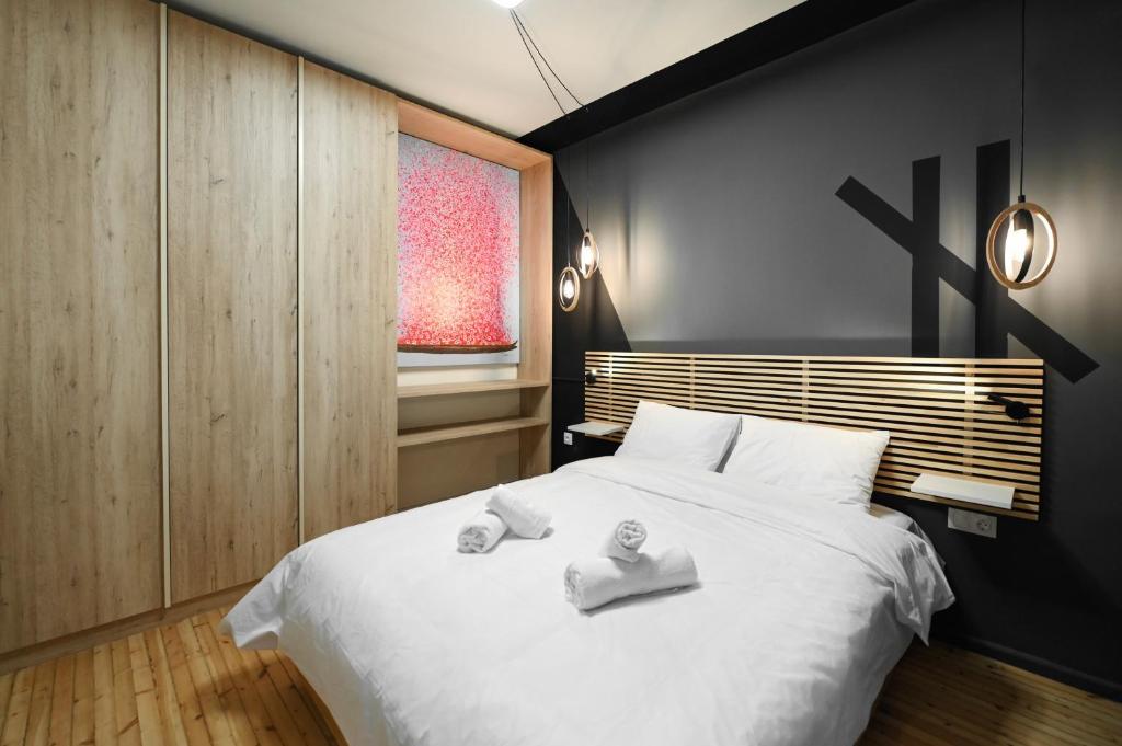 sypialnia z dużym białym łóżkiem z ręcznikami w obiekcie MORE LIFE #Unique Appartment In City Heart w Salonikach
