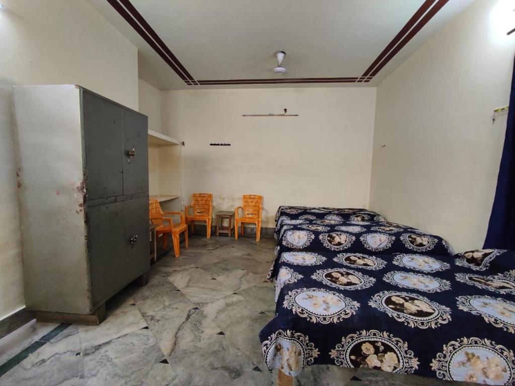 a bedroom with a bed and a table and chairs at Divisha PG House Sharing Beds Only for boys in Bareilly