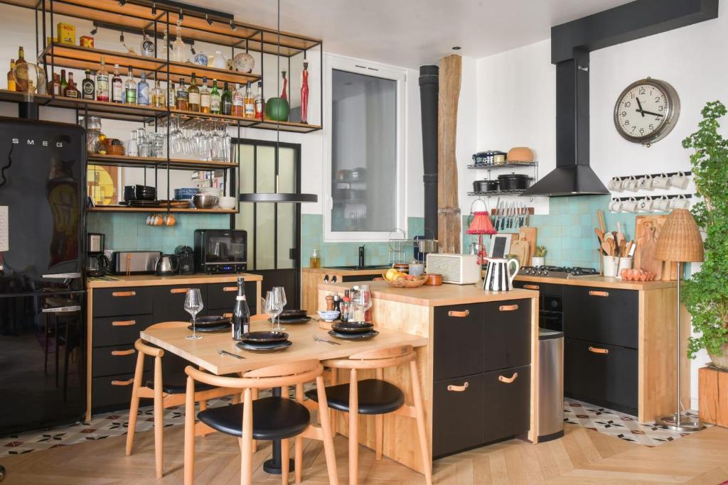 a kitchen with a table with chairs and a clock at Contemporary T3 in the heart of Bastille Paris - Welkeys in Paris