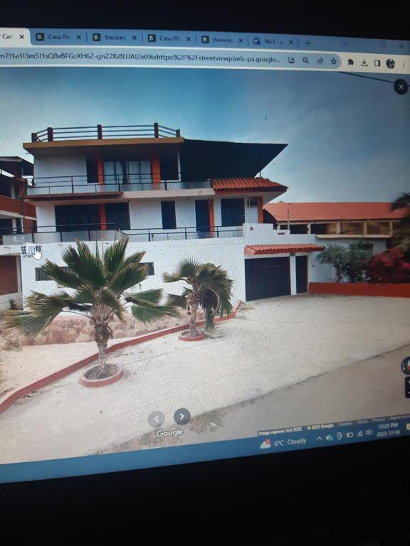 una foto de una casa con palmeras delante en Casa Piscina, Punta Mero, en Talara