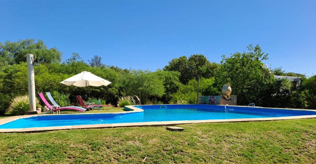 una piscina en un patio con sombrilla en Surya- en La Casa de Nanda en San Javier