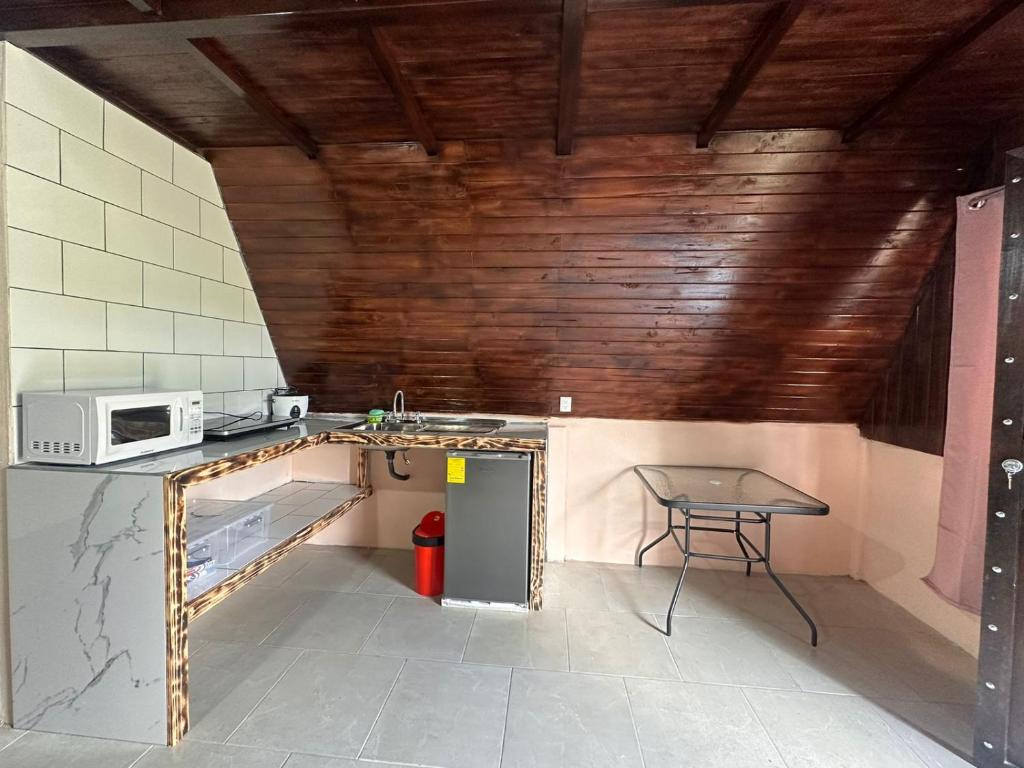 a small kitchen with a table and a microwave at Bungalows Tenorio Montand Lodge in Upala