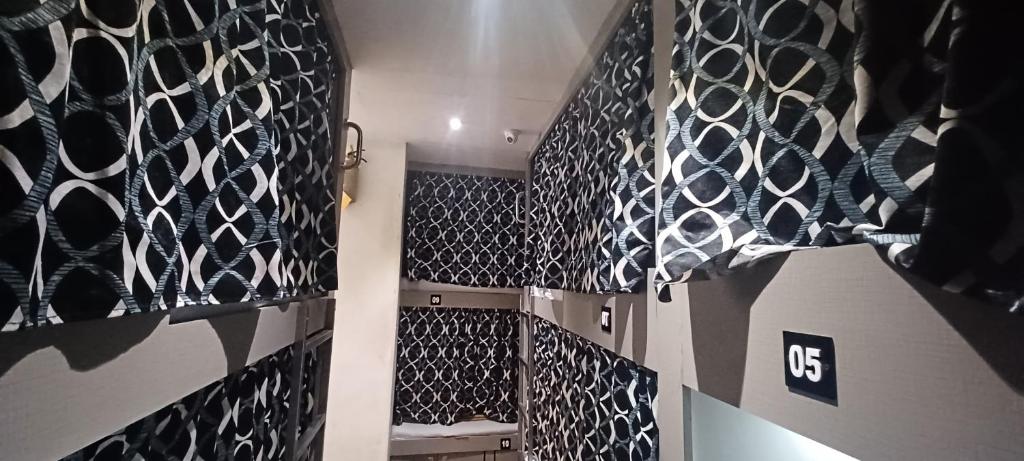 a room with black and white tiles on the wall at New Passenger Dormitory in Mumbai