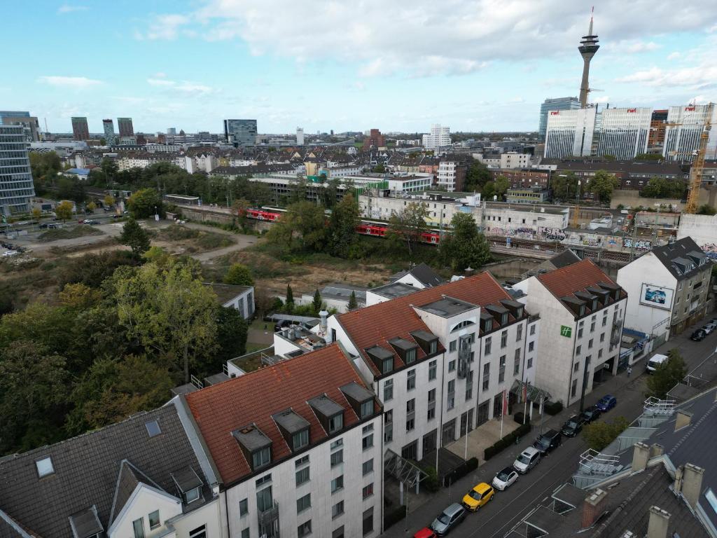 une vue aérienne d'une ville avec des bâtiments et un train dans l'établissement 4* Boutique Zimmer am Düsseldorf Hafen + ÖPNV & TG, à Düsseldorf