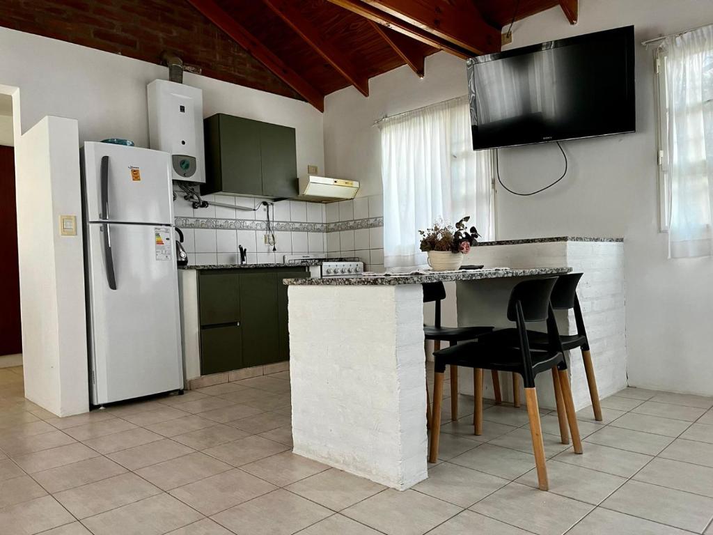 uma cozinha com um frigorífico, uma mesa e cadeiras em La calma em Puerto Madryn
