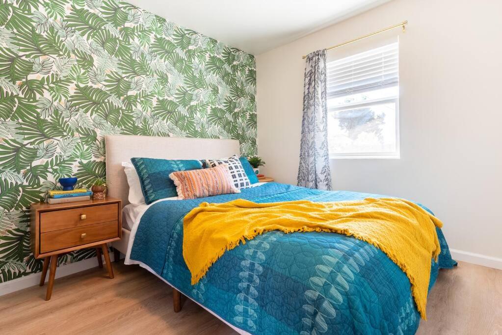een slaapkamer met een bed met een blauwe en gele deken bij Casita Amarilla, Tiny House in San Diego