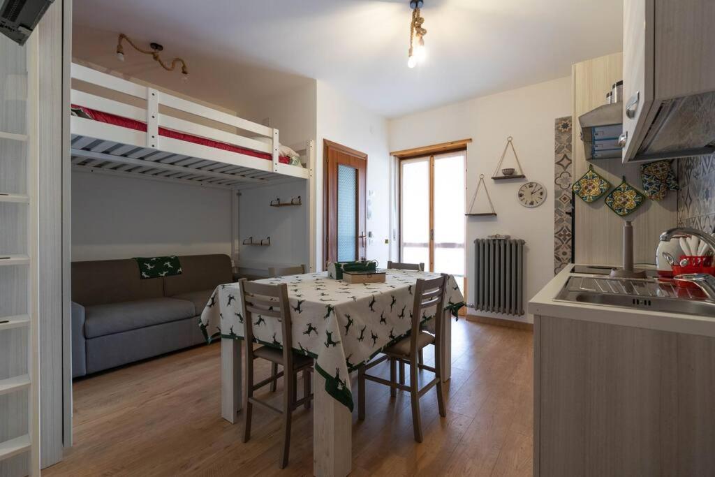cocina y sala de estar con mesa y sillas en Rifugio a 15min dalle piste da sci, en Frabosa Sottana