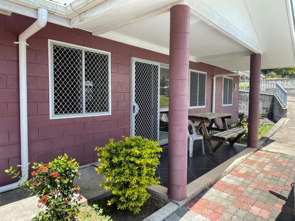 Casa rosa con porche y mesa de picnic en Keris Rental Houses, en Vaitele