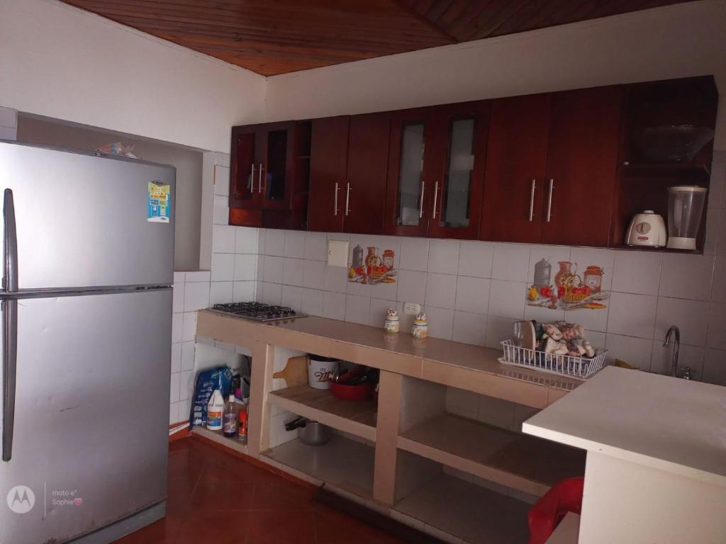 - une cuisine avec des placards en bois et un réfrigérateur blanc dans l'établissement Casa Ana, à Santiago