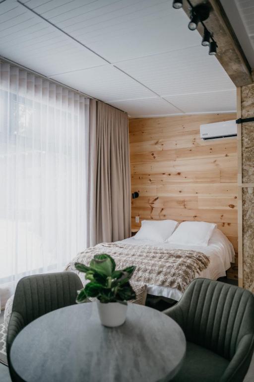 a bedroom with a bed and a table and chairs at Le 2800 du Parc in Shawinigan
