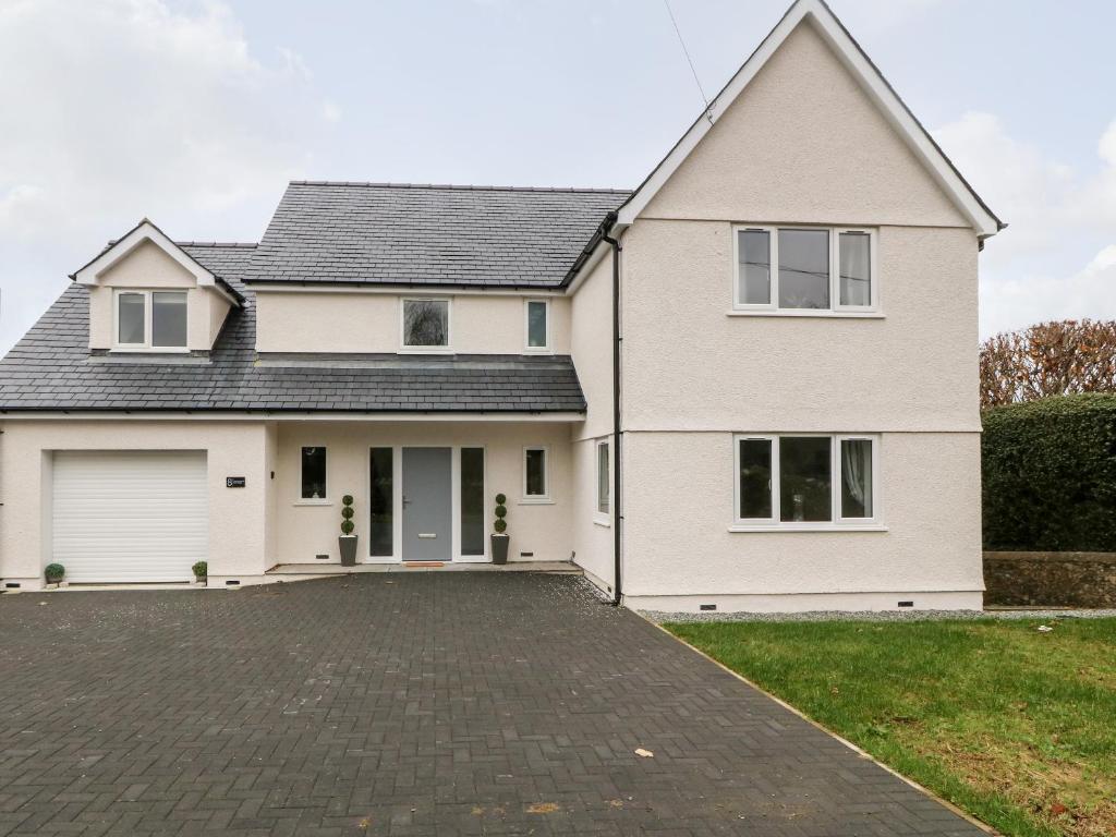 a white house with a driveway at White Bull House in Amlwch
