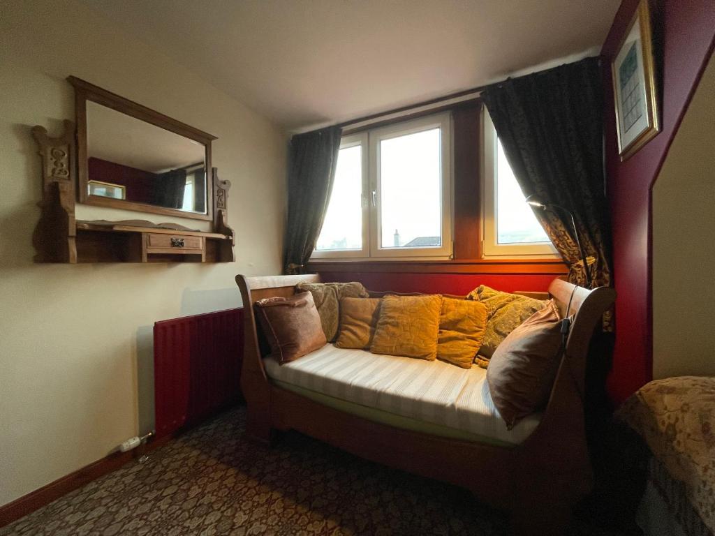 um sofá sentado num quarto com uma janela em Ramadale B&B em Stornoway