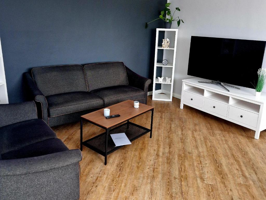 ein Wohnzimmer mit einem Sofa und einem Flachbild-TV in der Unterkunft Moorparadies FRI-Südliches Friesland in Bockhorn