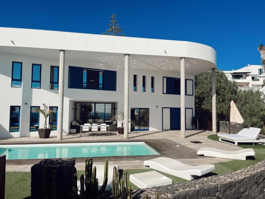 a large white house with a swimming pool at Villa Ramimedi - Vistas al Mar in Puerto del Carmen