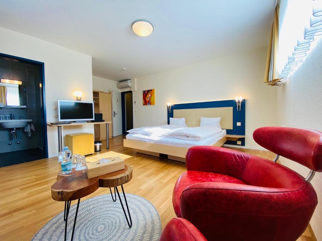 Habitación de hotel con cama, sofá y sillas en Vinum at Felmis SELF CHECK-IN, en Lucerna