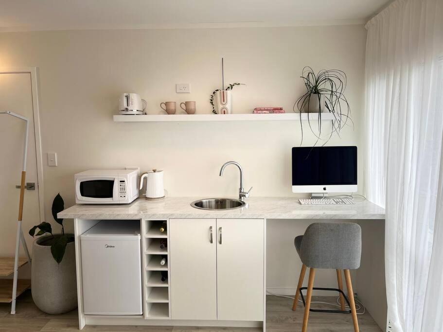 a kitchen with a desk with a computer on it at Pāpāmoa Beach Studio Oasis in Papamoa