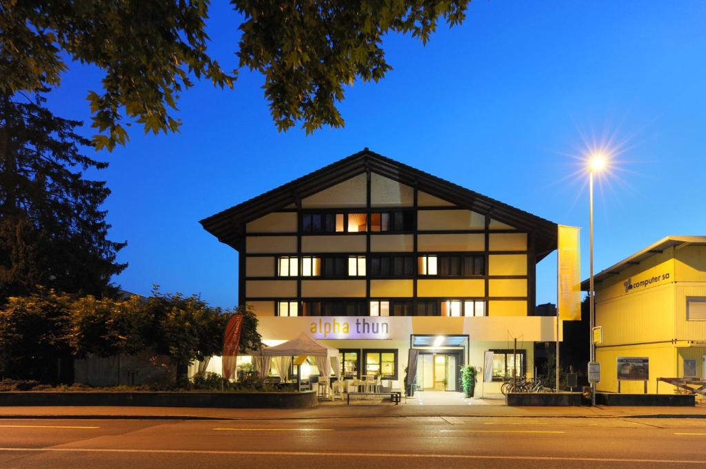 un edificio frente a una calle por la noche en Hotel Alpha Thun, en Thun