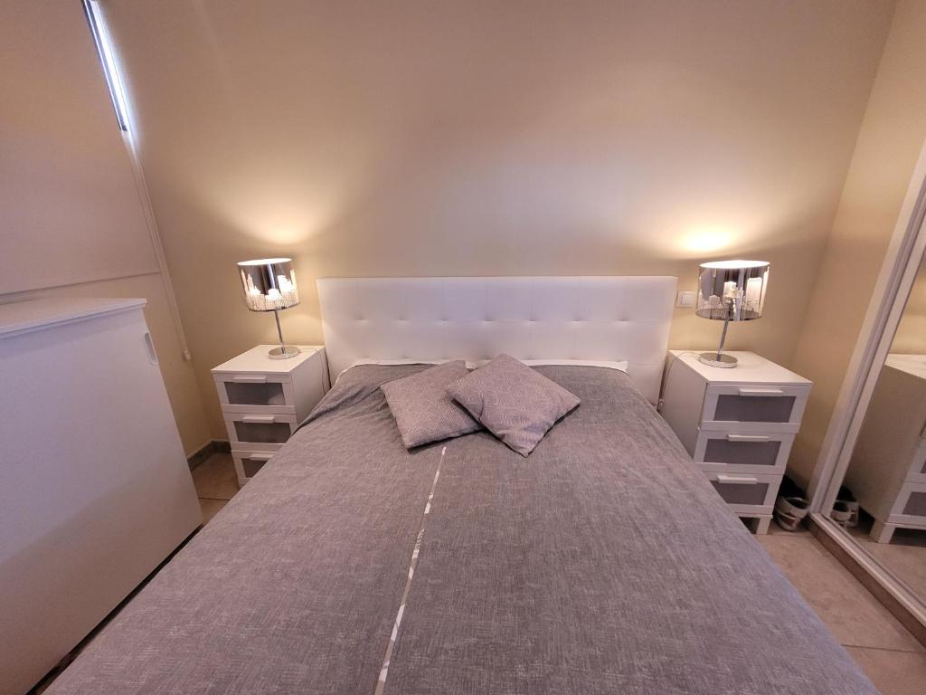 ein Schlafzimmer mit einem großen Bett mit zwei Nachttischen in der Unterkunft Apartment Mananem in Playa del Ingles