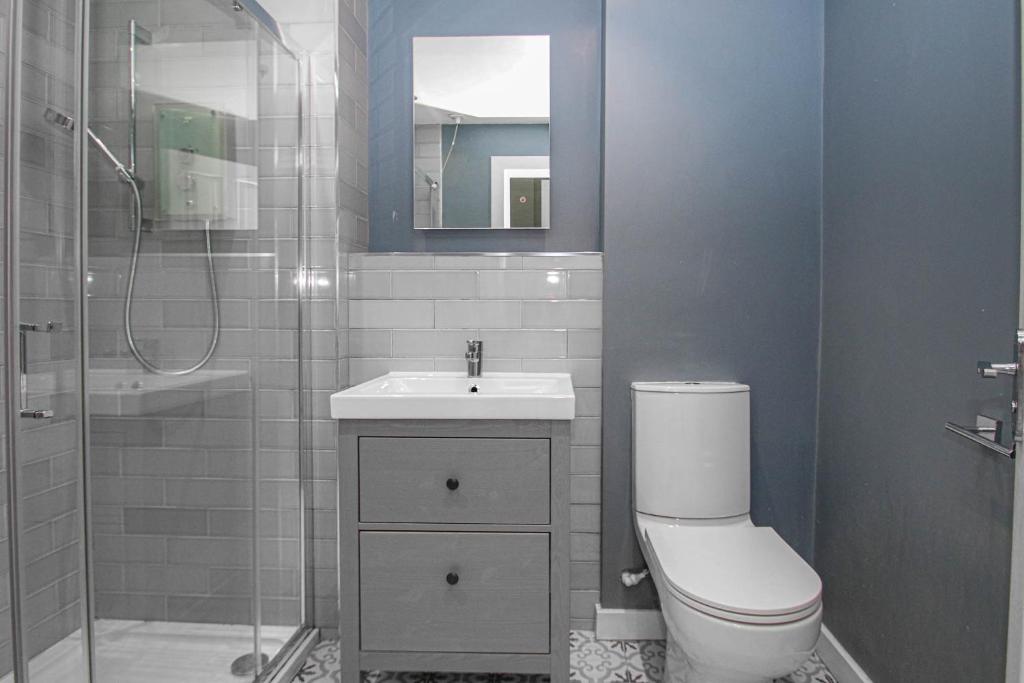 a bathroom with a toilet and a sink and a shower at Finnieston Apartment in Glasgow