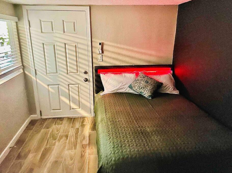 a bedroom with a bed with a red headboard and a door at New Midtown Studio with Full Kitchen (Unit C) in Phoenix