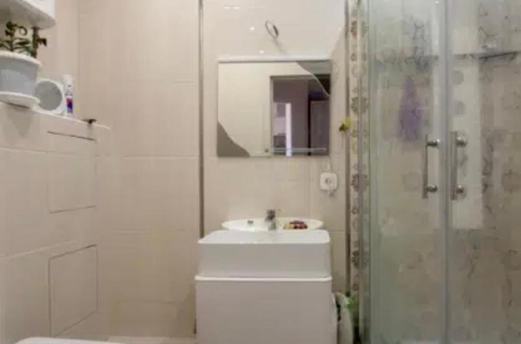uma casa de banho com um WC, um lavatório e um espelho. em VIP apart 610 em Tbilisi