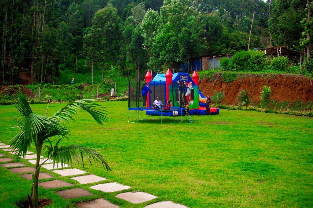 un parque infantil en un campo de césped verde en SpringWells Hotel ltd en Maua