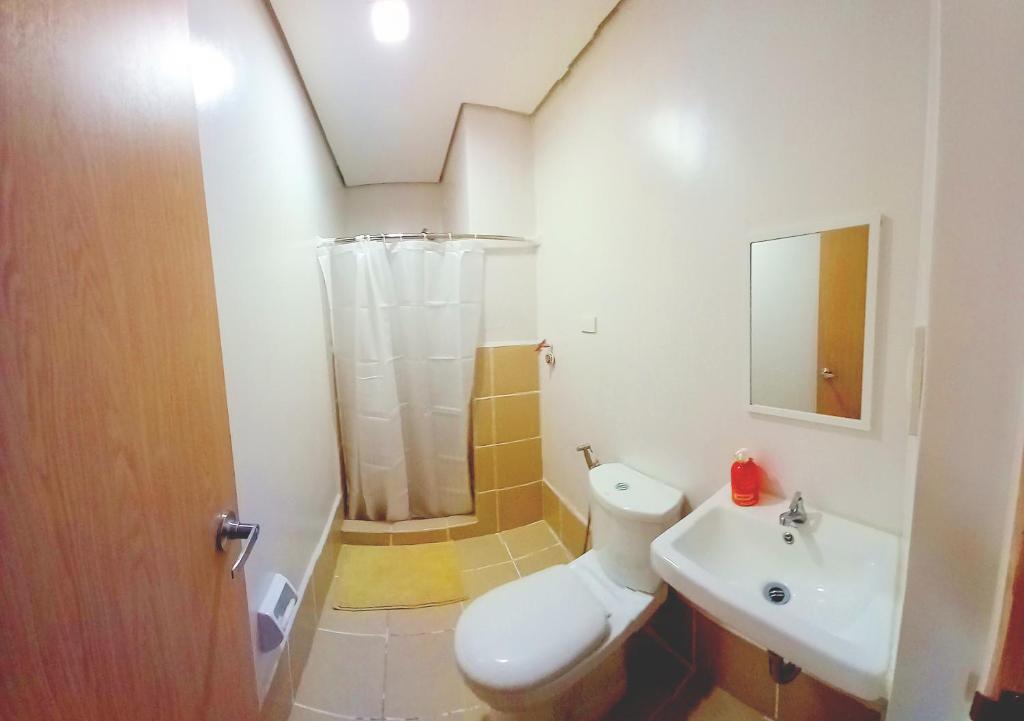 a bathroom with a toilet and a sink and a shower at Ace That Condo Staycation Cheer Residences beside SM Marilao in Marilao