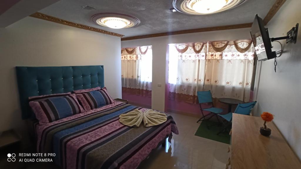 1 dormitorio con 1 cama, mesa y sillas en Hotel la Pampa, en Alto Hospicio