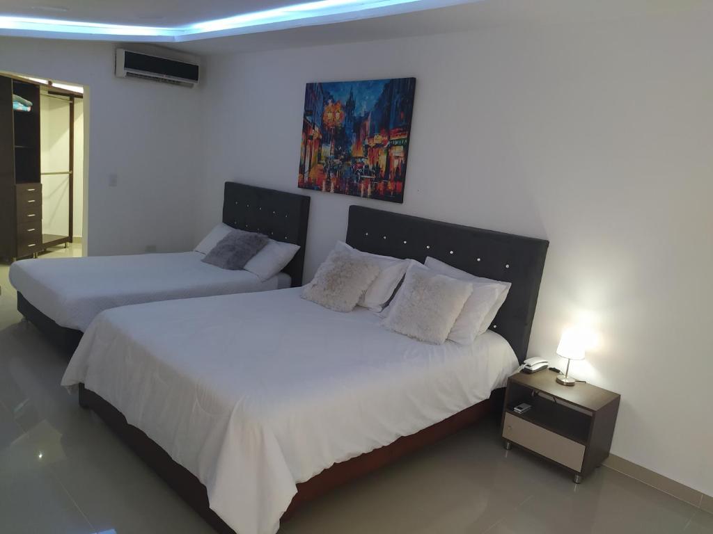 1 dormitorio con 2 camas y un cuadro en la pared en Apartamento Amoblado en Tuluá, 2 Habitaciones, en Tuluá