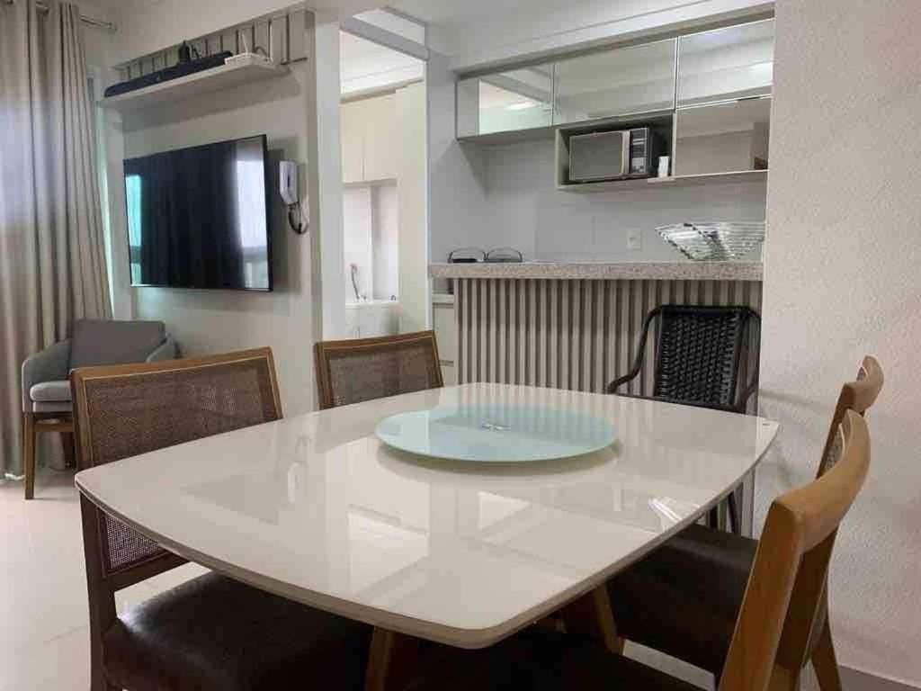 una mesa blanca y sillas en la sala de estar. en Apartamento 2Q Próximo ao Albert Einstein EC1003, en Goiânia