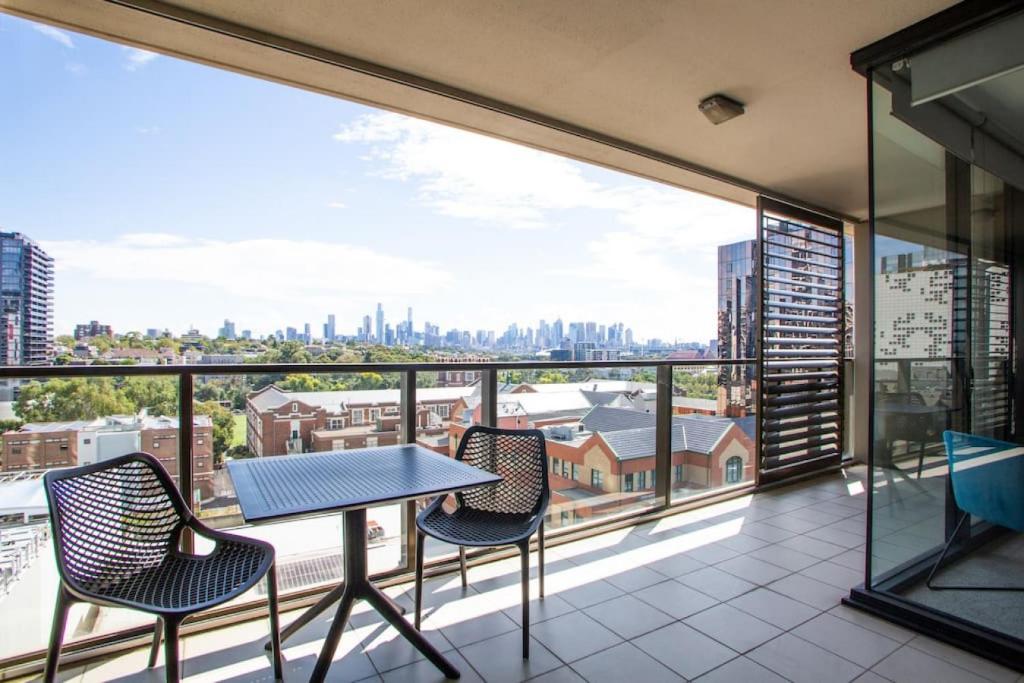 a balcony with a table and chairs and a view of the city at Sapphire of South Yarra - two bedroom condominium in Melbourne