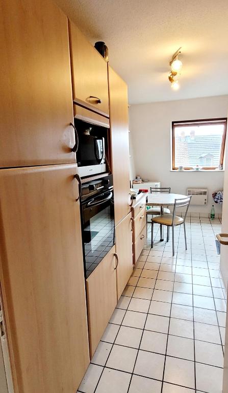 cocina con nevera y mesa en L&#39; Appart BELLE VUE GARE ET CENTRE 10 mn à pied GARAGE GRATUIT, en Colmar