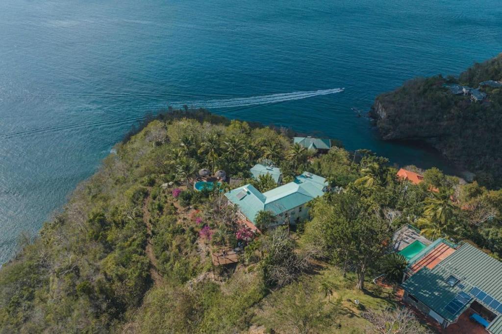 eine Luftansicht eines Hauses auf einem Hügel neben dem Meer in der Unterkunft Amazing mountain top home with stunning views in Marigot