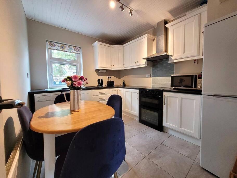 a kitchen with a table with a vase of flowers on it at Killawalla Cottage, Westport. in Westport