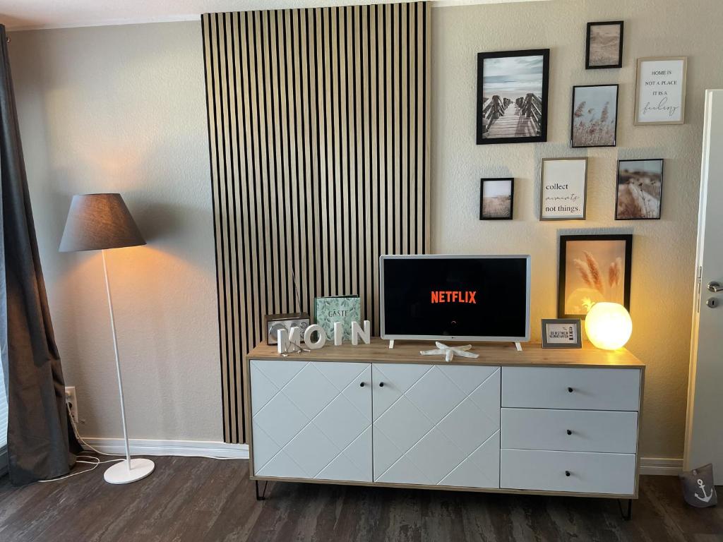a room with a dresser with a television on it at Wolkenlos in Butjadingen